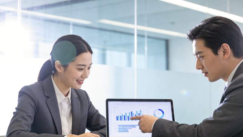 职场男女共同分析电脑屏幕数据图表图片