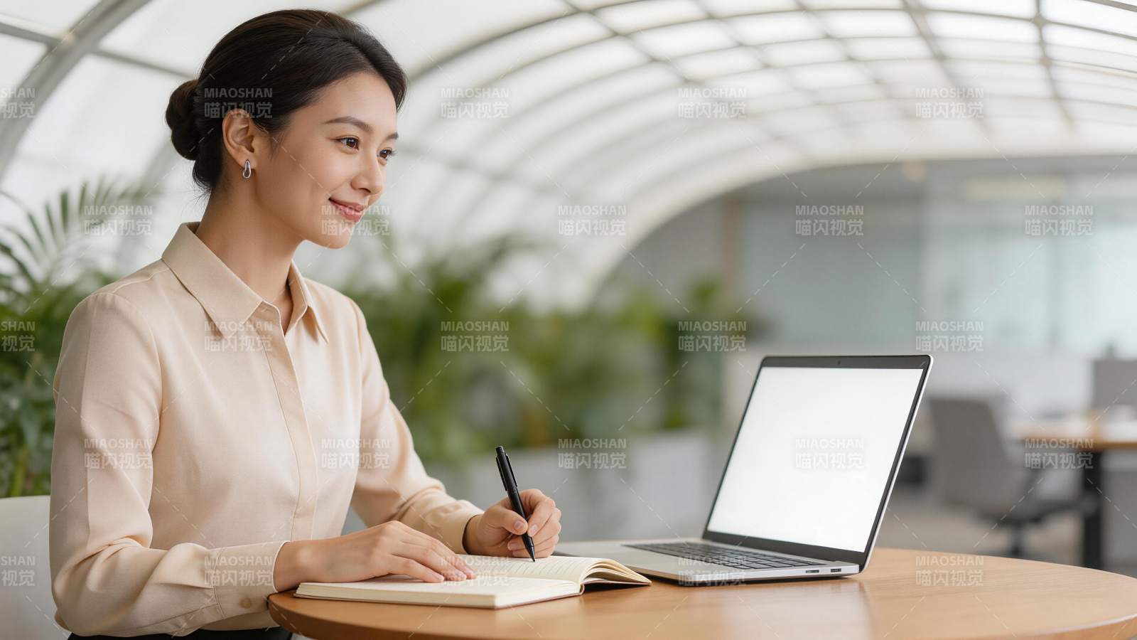 职场女性在明亮办公室使用笔记本电脑记录图片