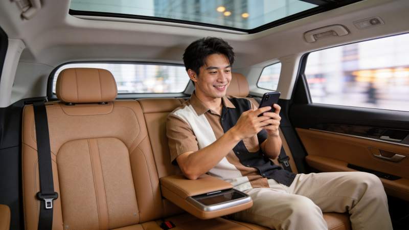 男子乘坐豪华轿车后排使用智能手机图片