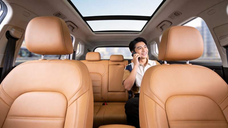 车内男子手持手机通话微笑场景图片