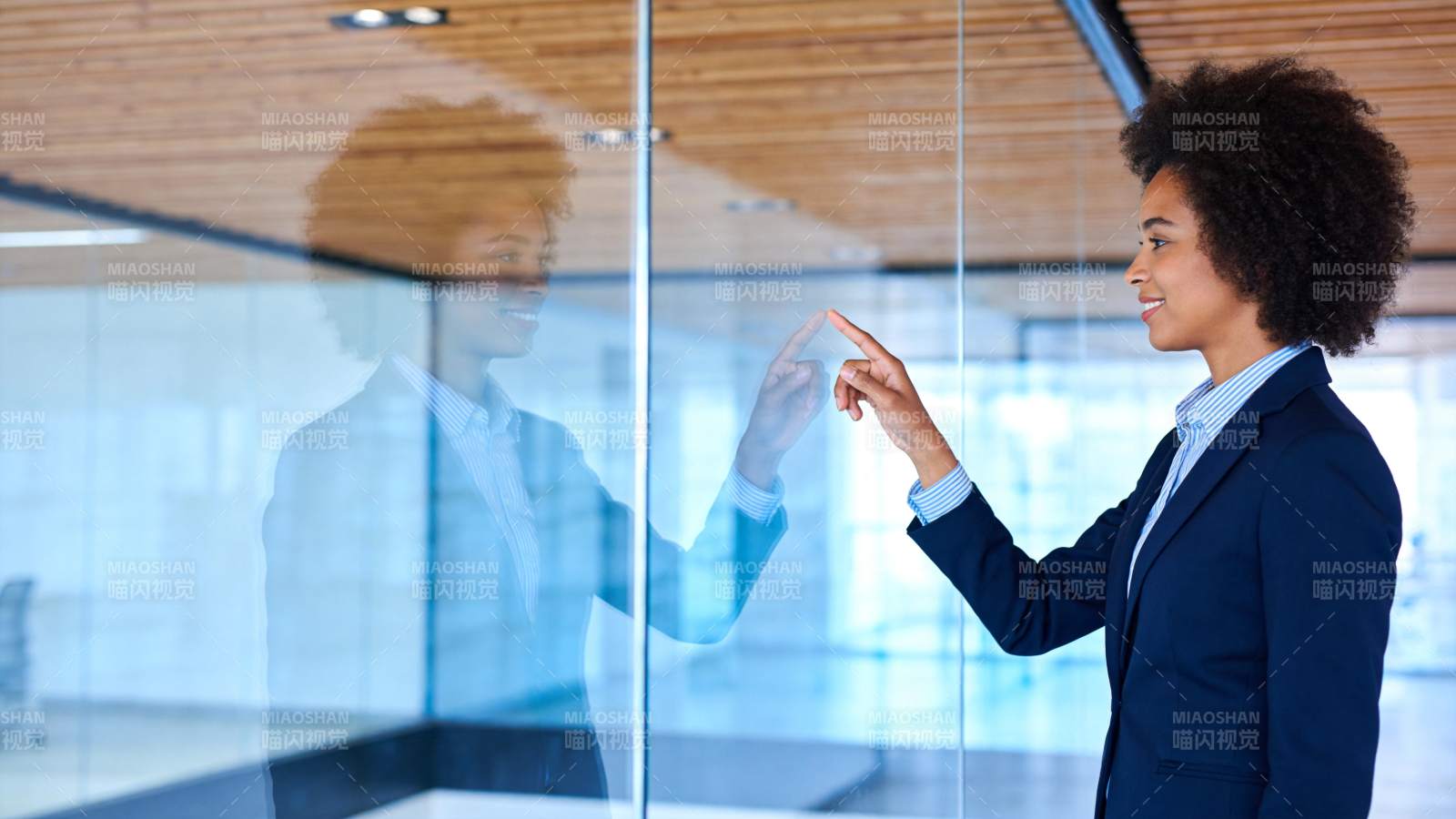 职场女性指尖触碰玻璃墙反射影像图片