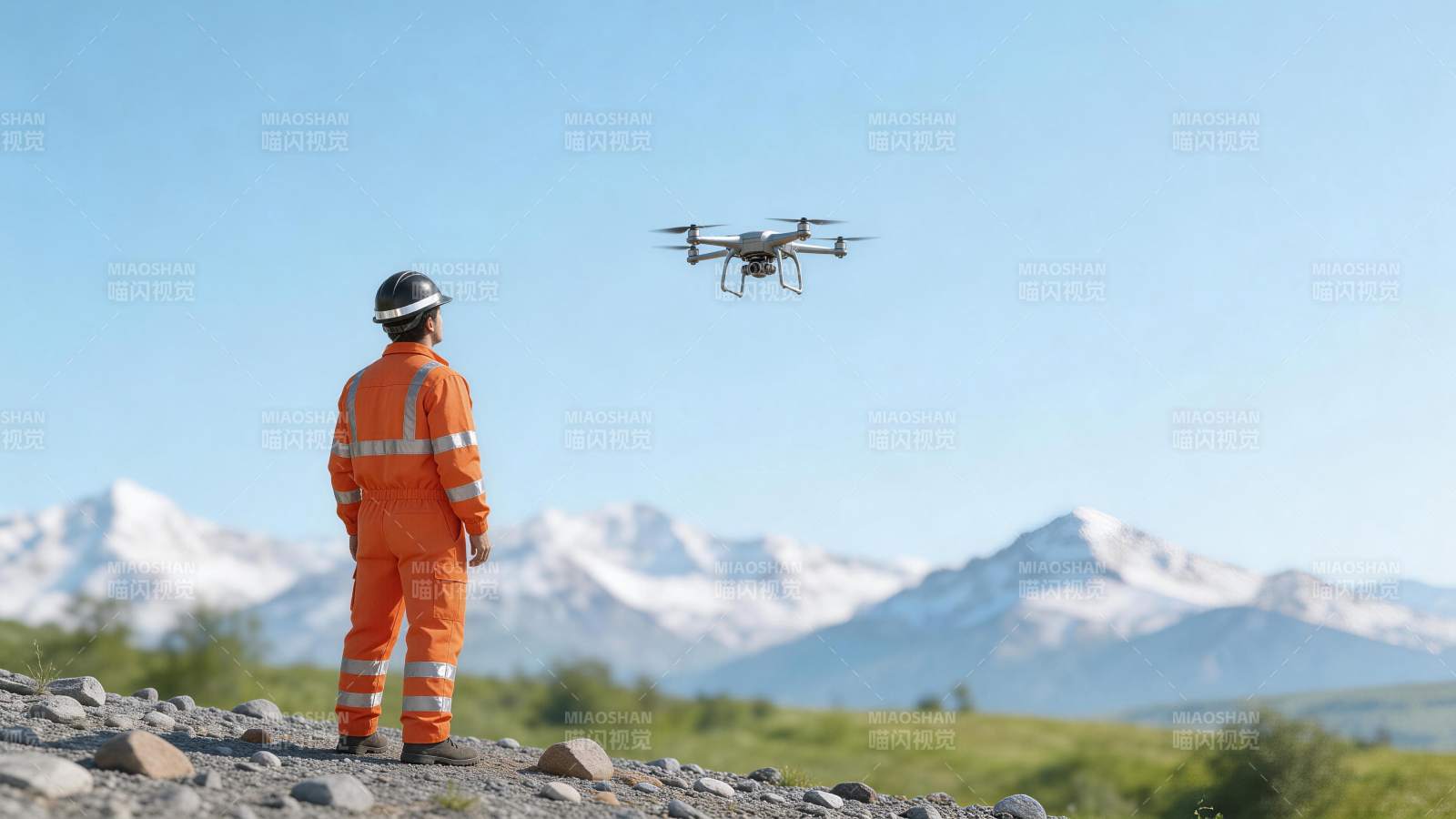 穿橙色工装人员操控无人机进行户外作业图片