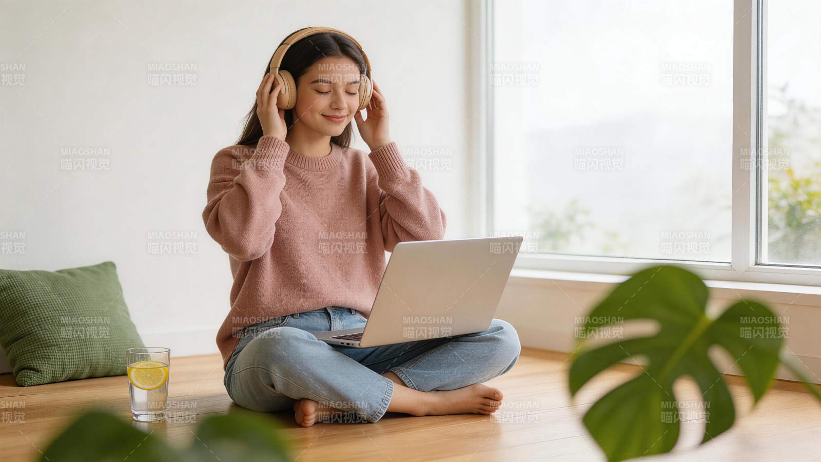 女子戴耳机坐地板用笔记本电脑听音乐图片