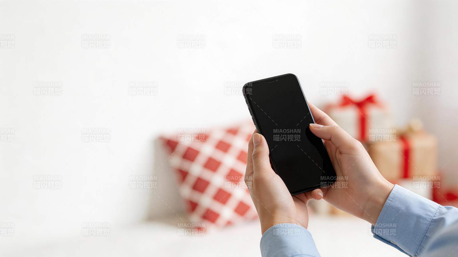 双手持黑色智能手机前景清晰背景虚化图片