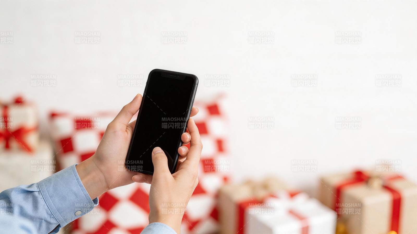 双手持黑色智能手机前景礼物盒背景图片