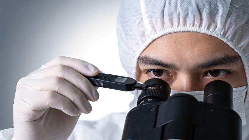 科研人员佩戴防护装备使用显微镜进行实验观图片