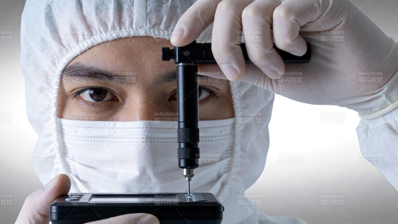 技术人员佩戴防护装备进行精密仪器操作图片