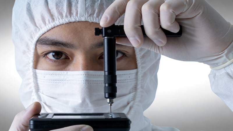 技术人员佩戴防护装备进行精密仪器操作图片