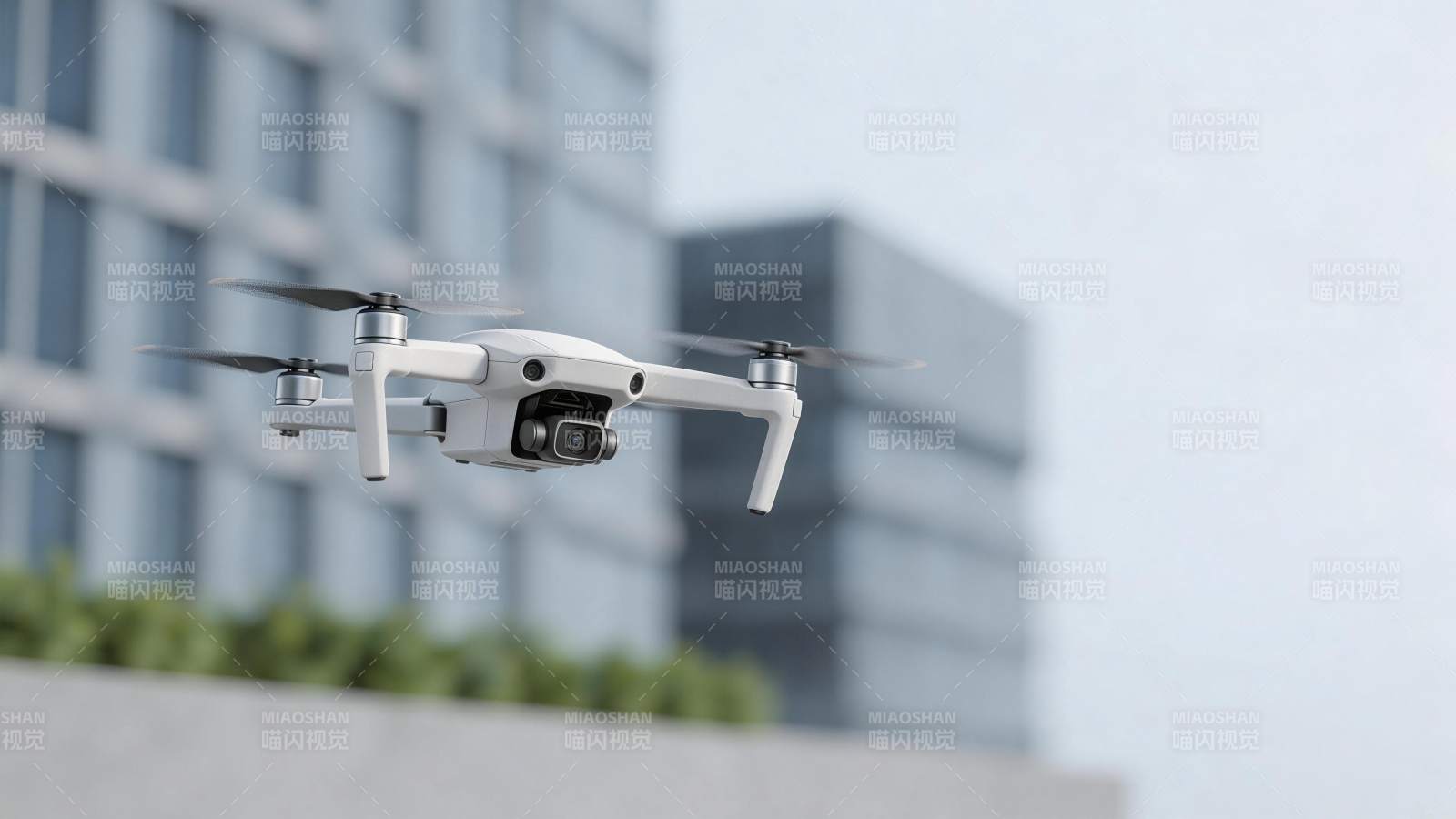 白色四轴无人机空中悬停拍摄城市建筑图片