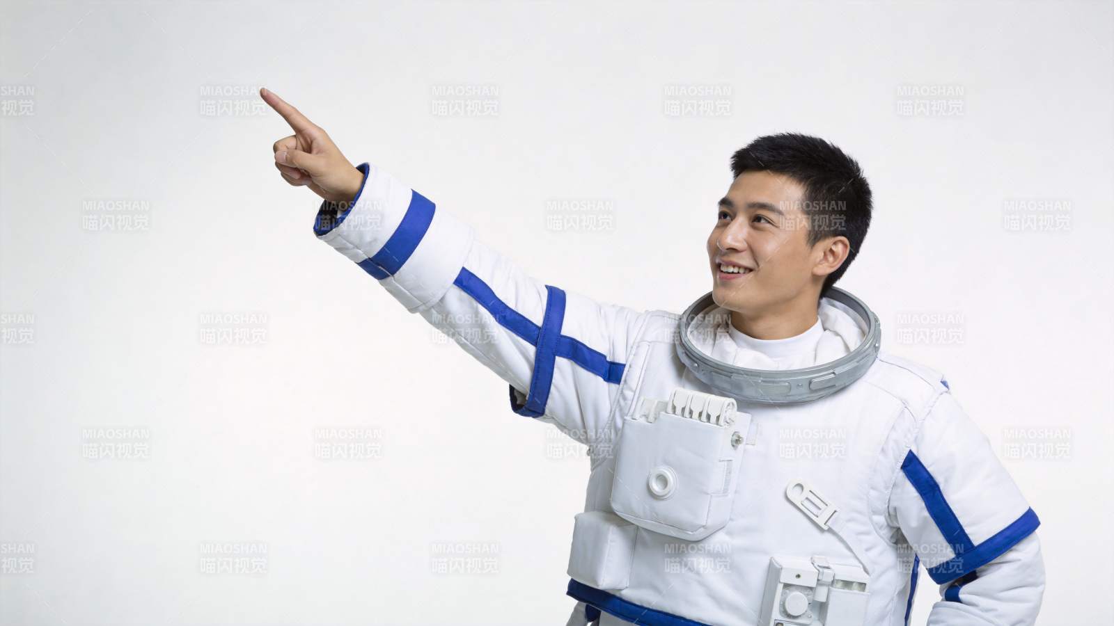 身穿白色宇航服男子指向右上方微笑图片