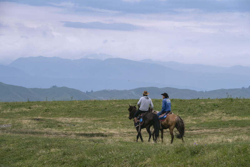草原骑马远眺山峦图片