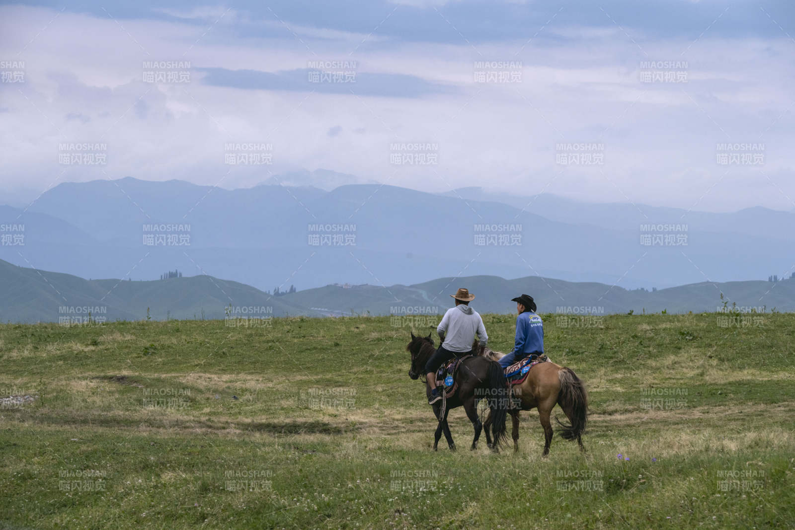 草原骑马远眺山峦图片