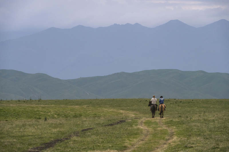 草原骑马远行图片
