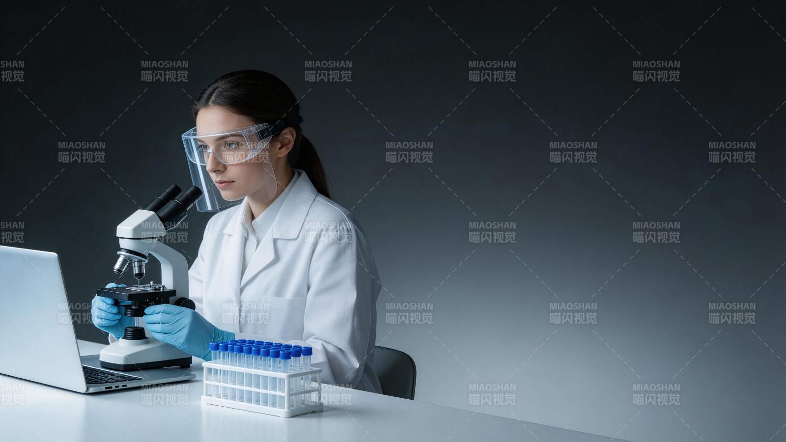 科研人员佩戴护目镜操作显微镜进行实验分析图片