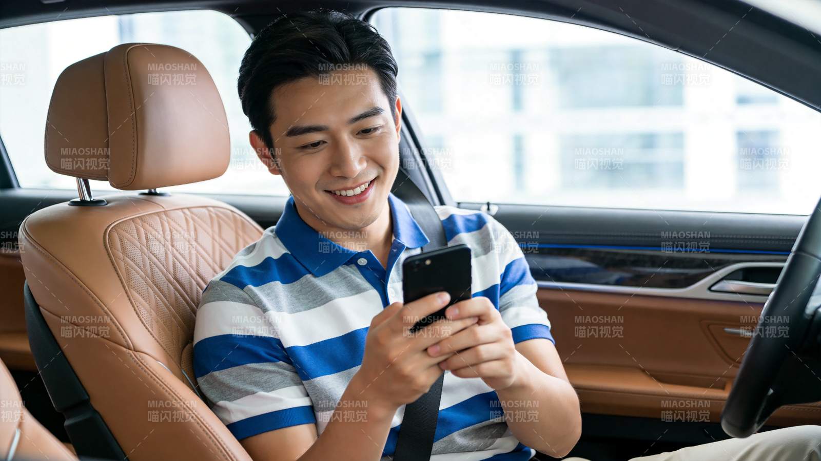 男子坐在车内使用智能手机微笑图片