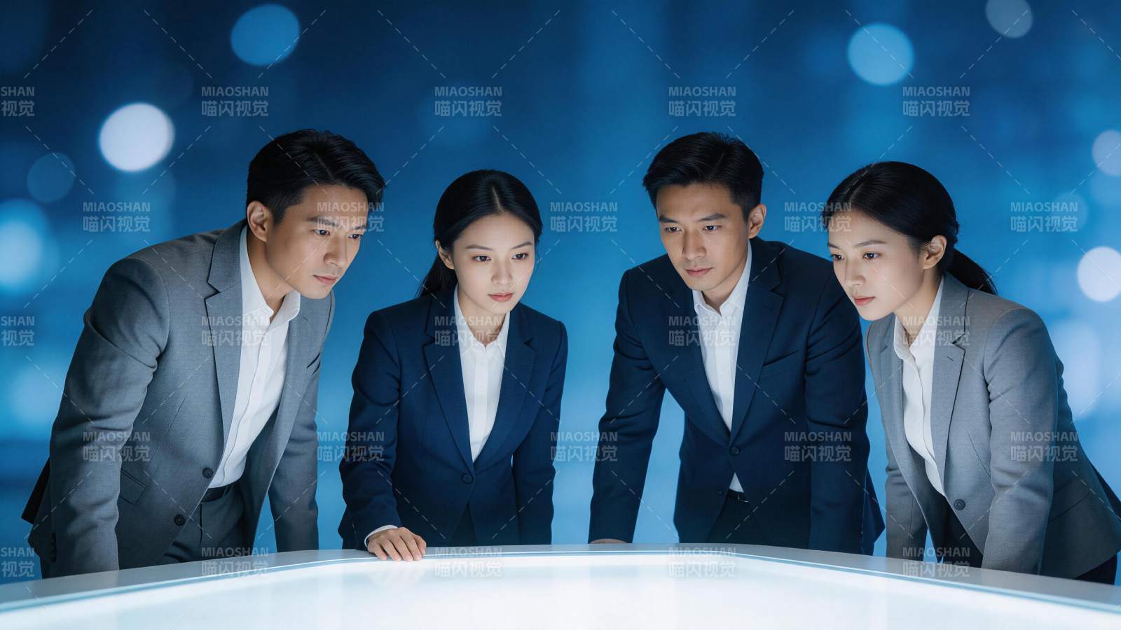 四位职场人士围看发光桌面专注讨论工作图片