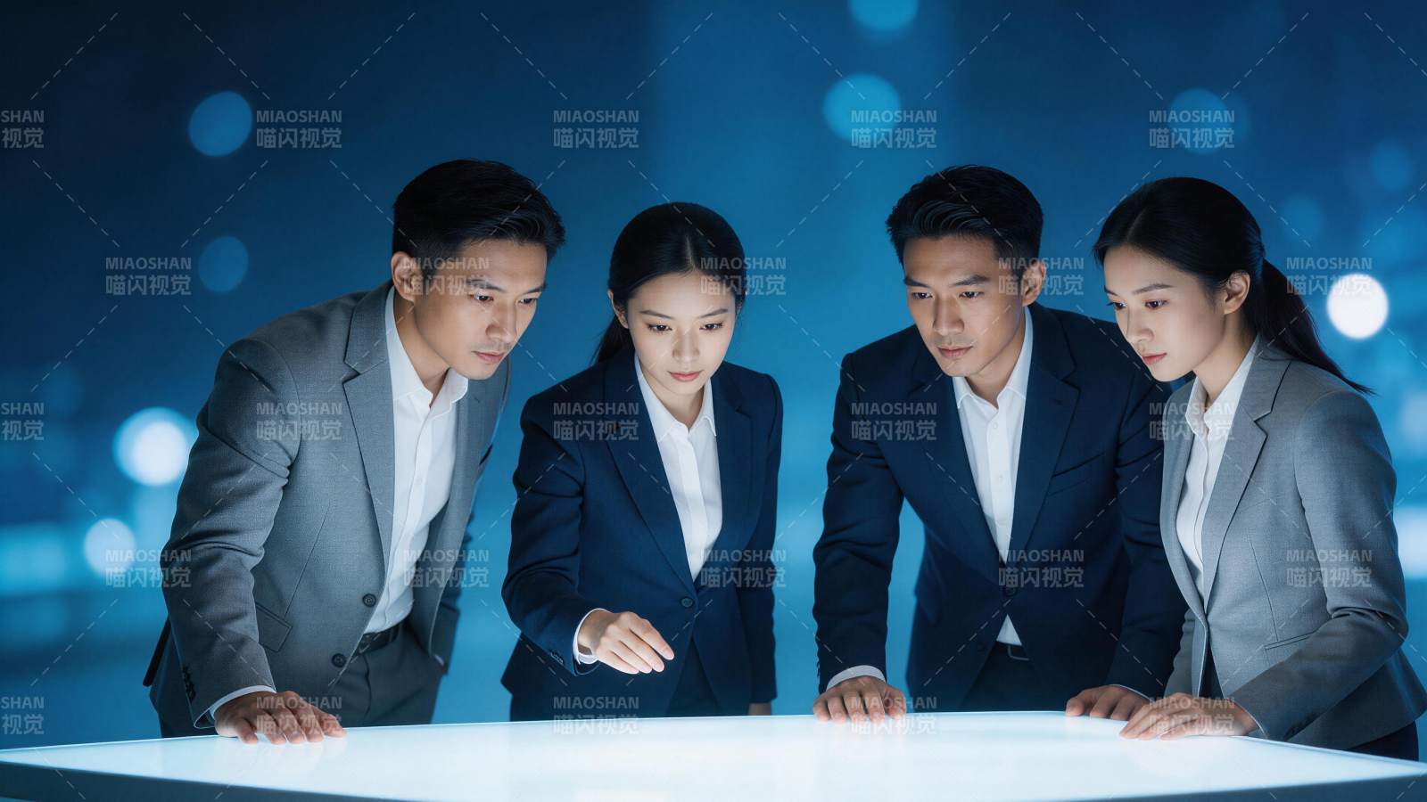 四位职场人士围看发光交互桌面进行协作图片