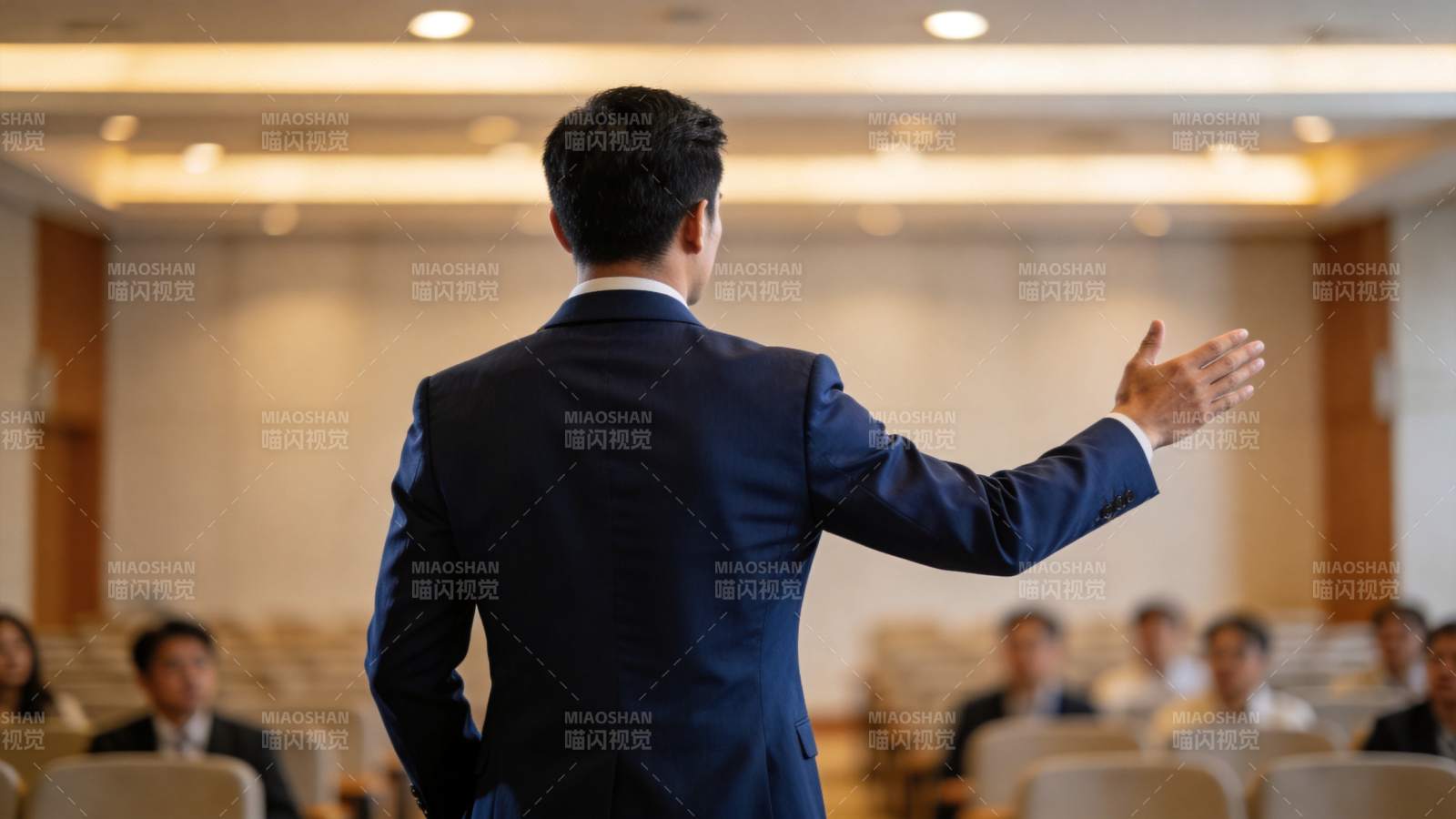 男士背对镜头在会议厅演讲手势示意图片