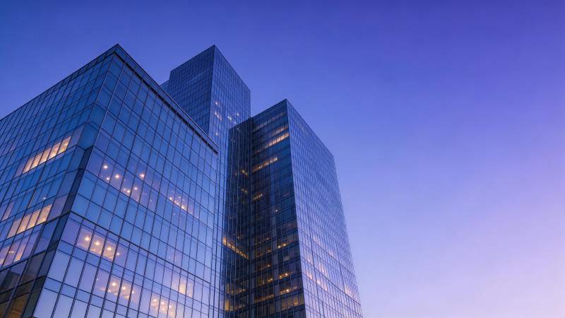 玻璃幕墙高楼在暮色天空下的剪影图片