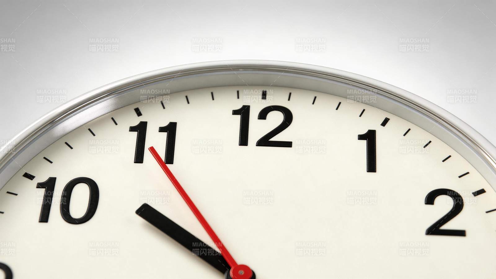 白色表盘金属边框挂钟特写显示十点五十五分图片