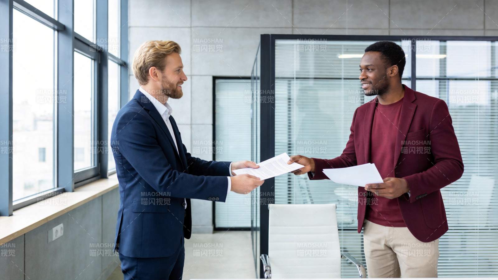 两位商务人士在办公室交接文件图片