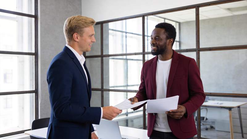 两位商务人士在办公室内交流文件图片