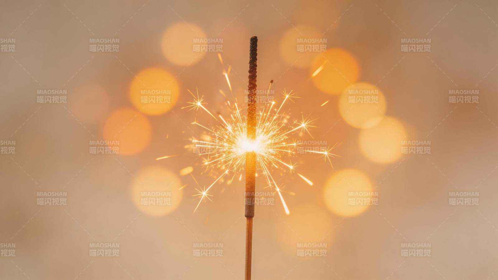 点燃的烟花棒在暖光虚化背景中绽放火花图片