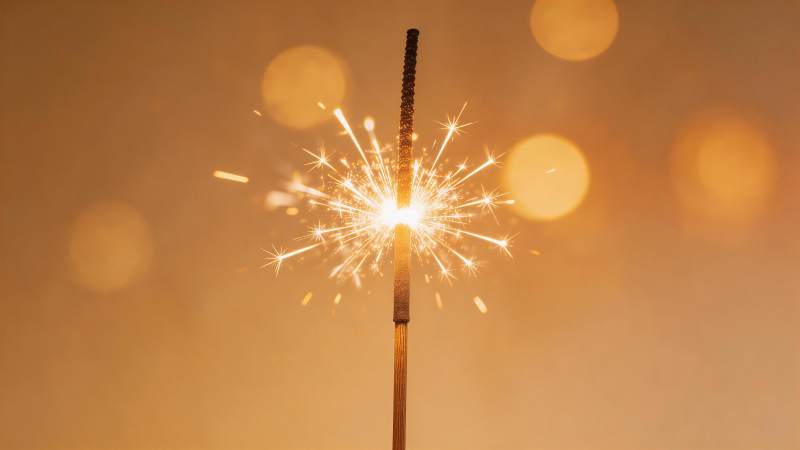 点燃的烟花棒发出明亮火花光芒图片