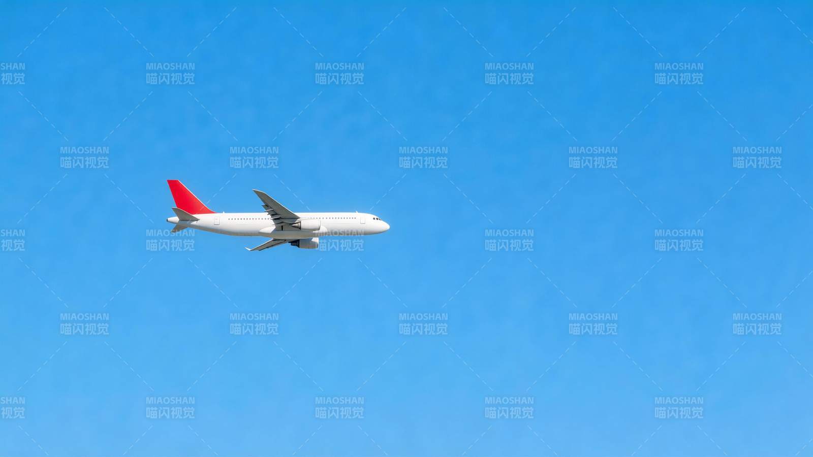 白色客机红尾翼蓝天飞行中图片