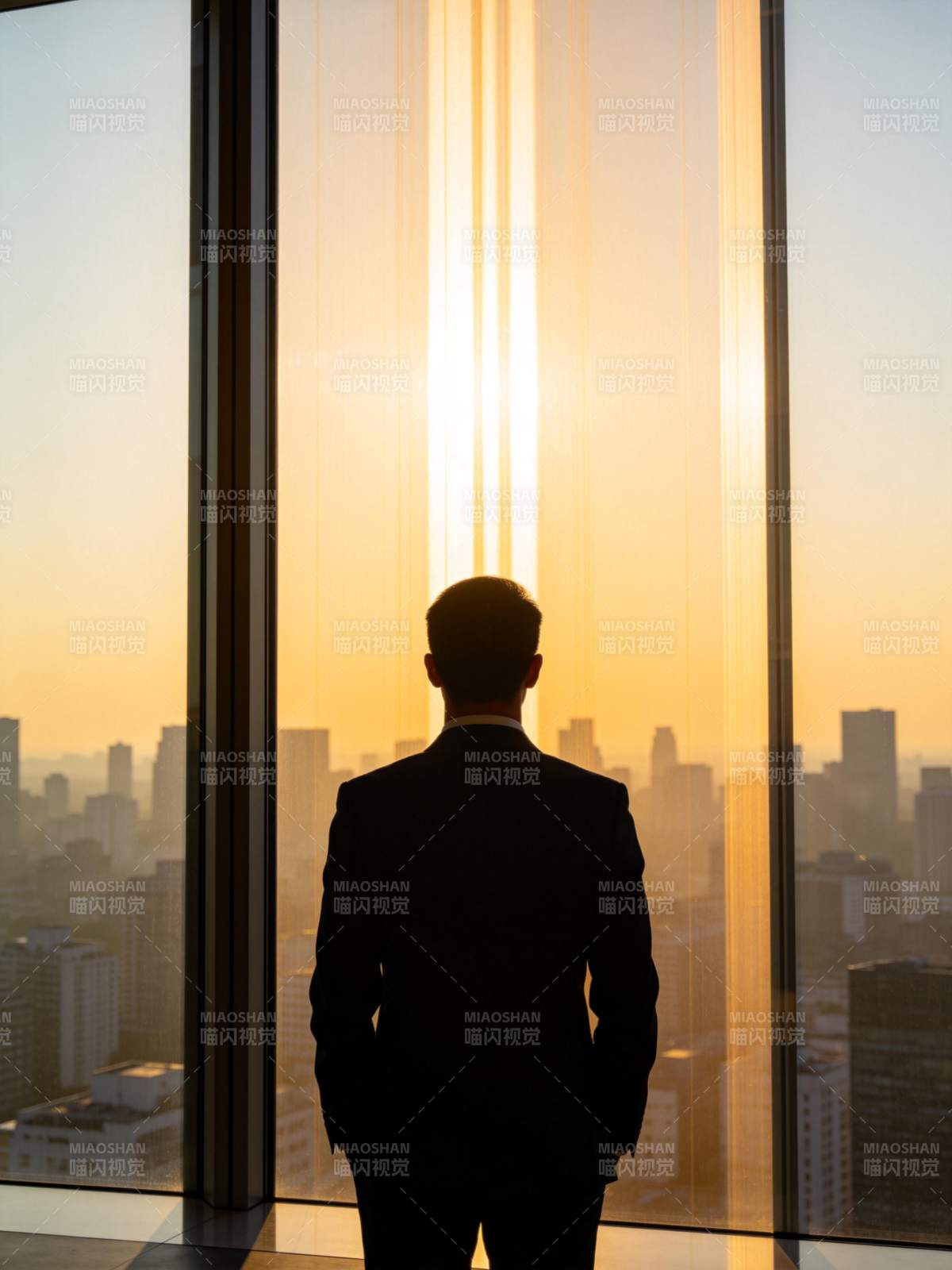 西装男子背影伫立高楼窗前眺望城市日落图片