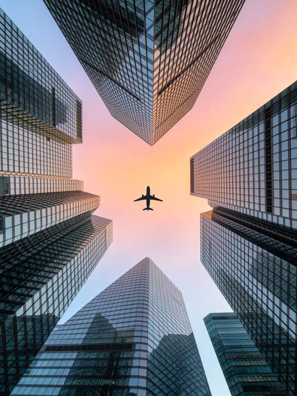 高楼林立间飞机飞越城市天际线图片