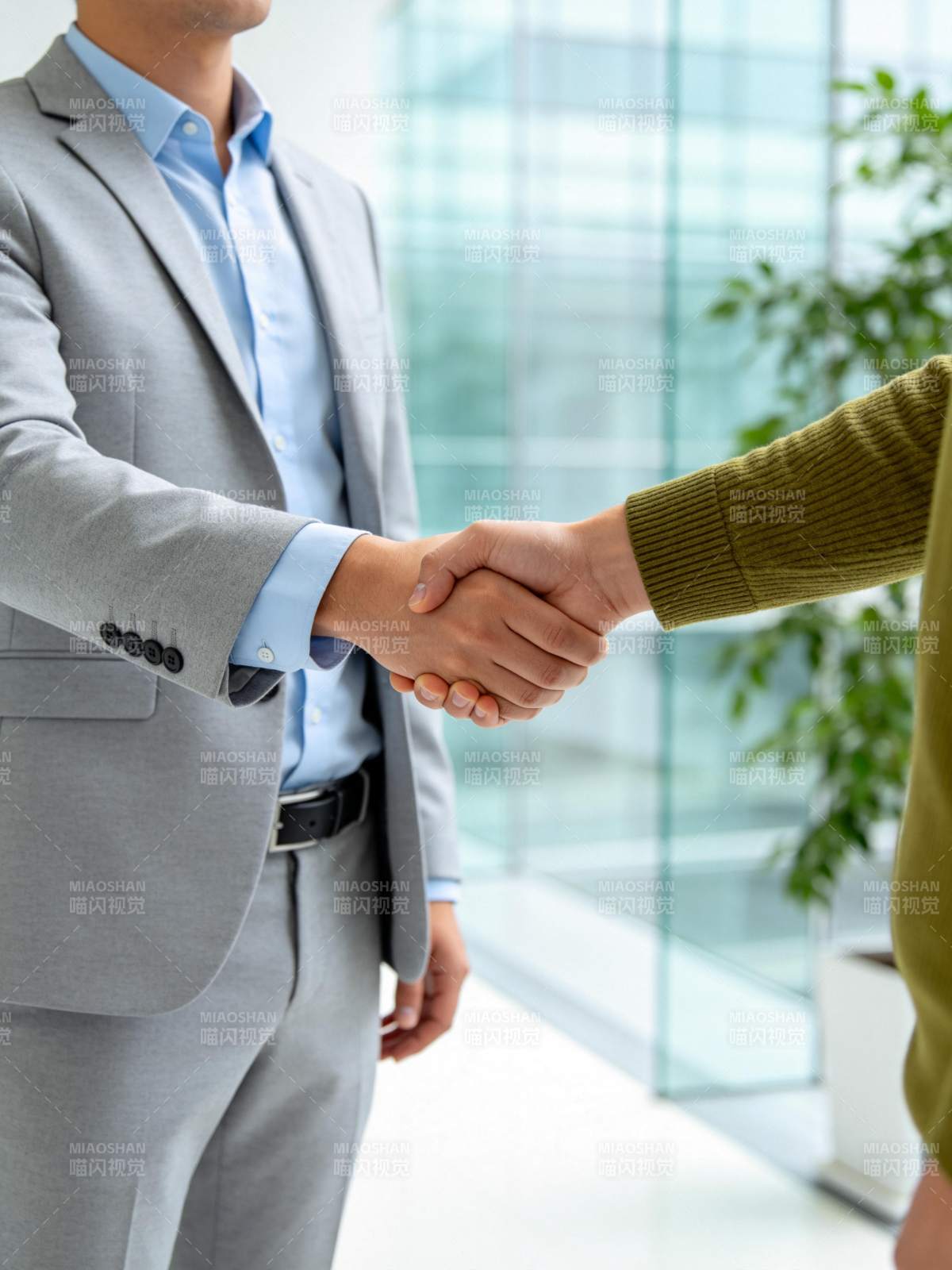 商务人士在办公室内握手达成合作意向图片