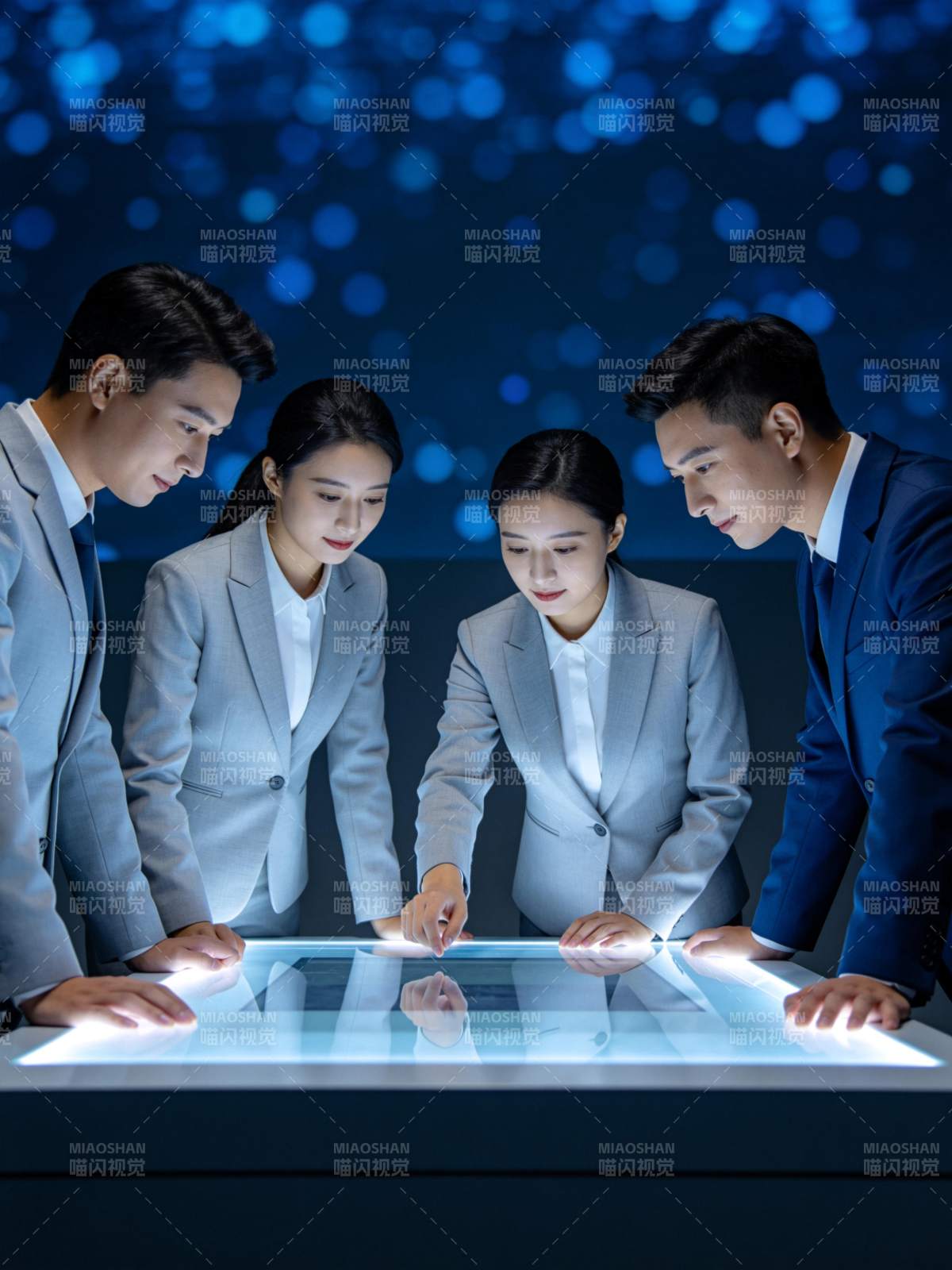 四位职场人员围看发光交互桌面操作演示图片