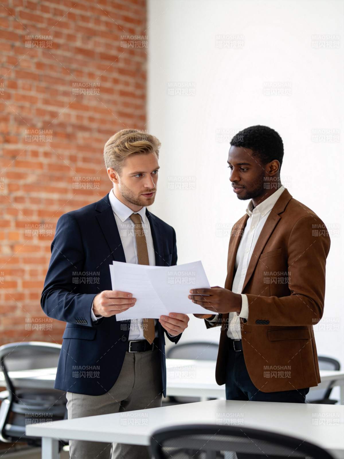 两位商务男士在办公室讨论文件内容图片