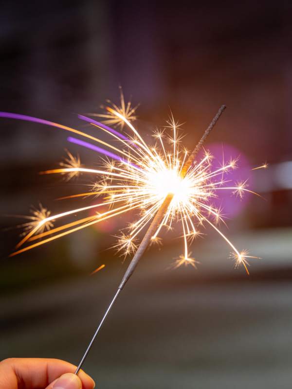 手持点燃的烟花棒发出明亮火花图片