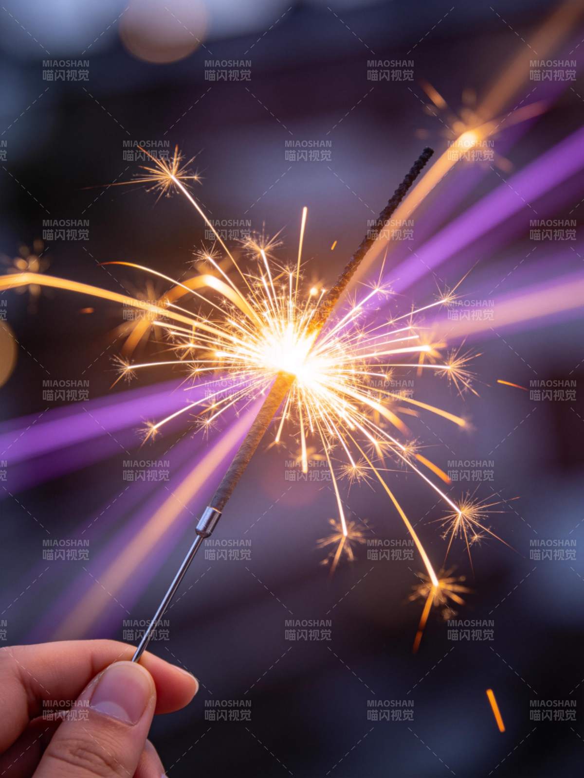 手持点燃的烟花棒发出耀眼火花图片