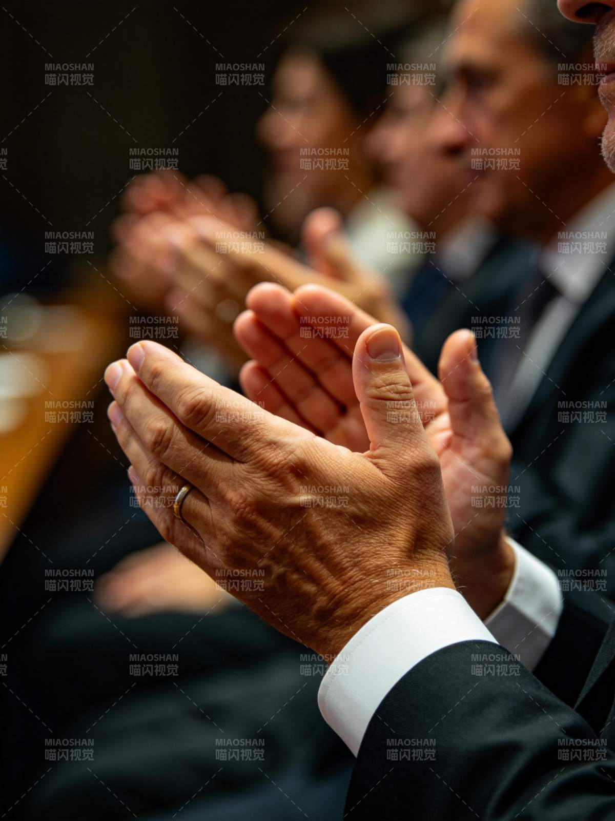 多人身着正装鼓掌场景特写图片