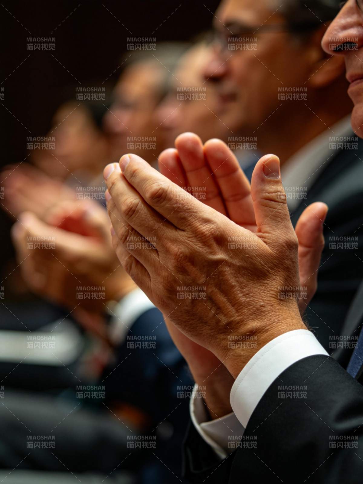 多人身着正装鼓掌场景特写图片