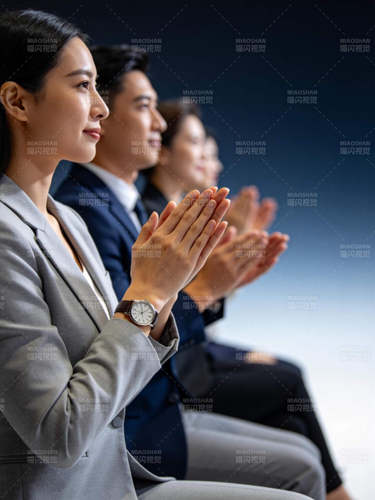 四位职场人士正装鼓掌专注观看前方图片