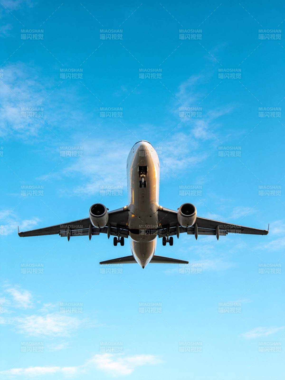 客机从正下方视角飞越蓝天背景图片