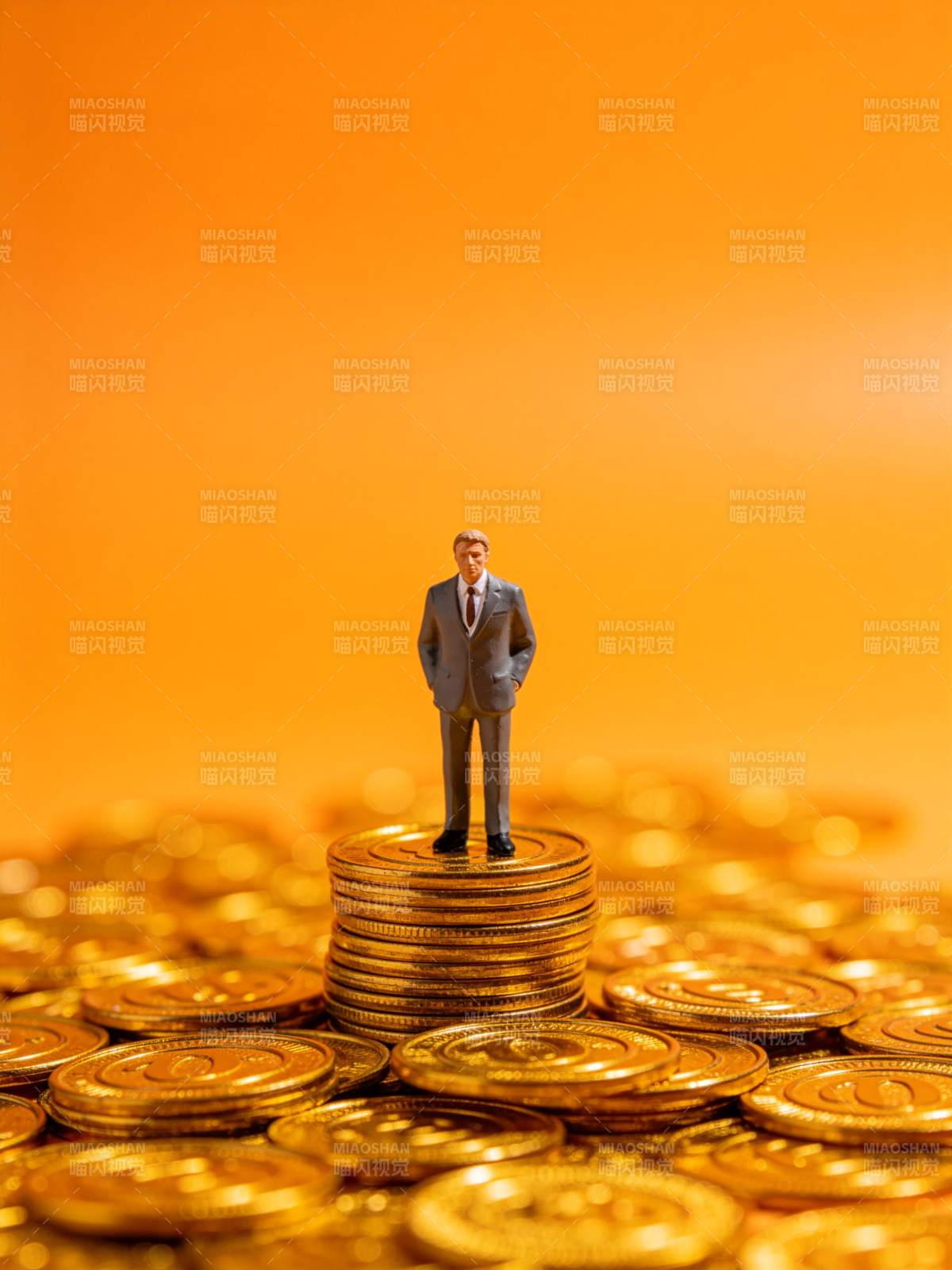 微型商人模型立于金币堆顶端图片