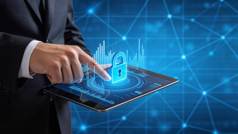 商务人士操作平板显示数字安全锁与数据图表图片