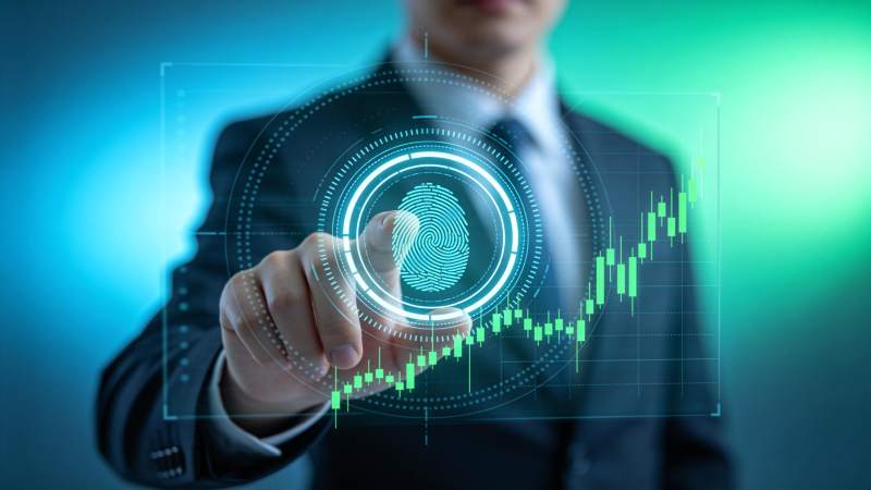 商务人士操作全息指纹识别与股市图表界面图片