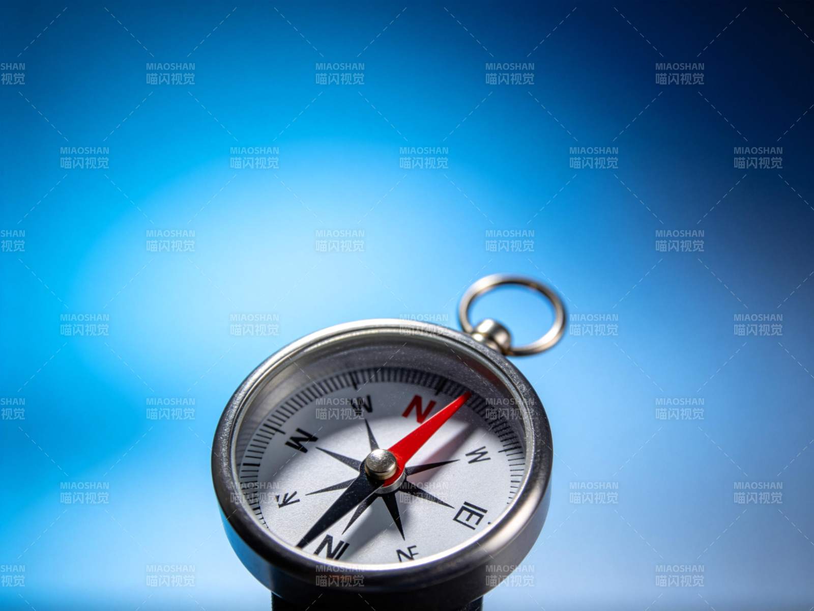 金属指南针特写指向北方背景蓝光图片
