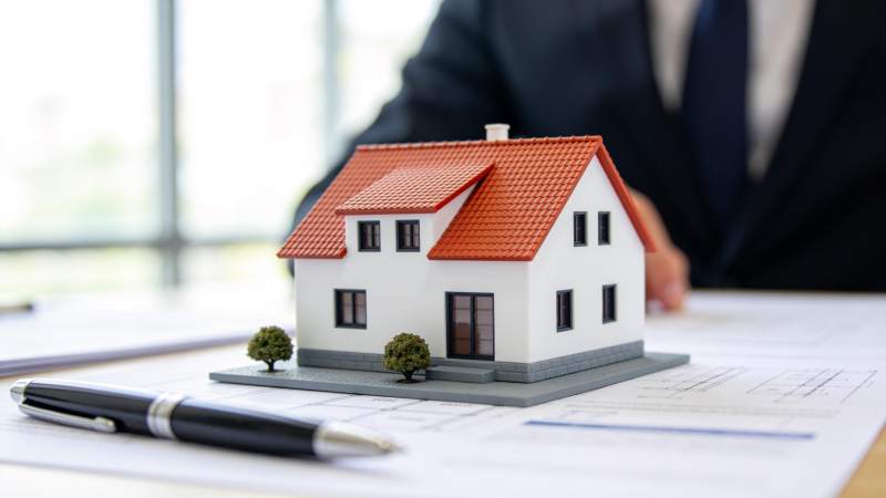 办公桌上房屋模型与图纸文件展示图片