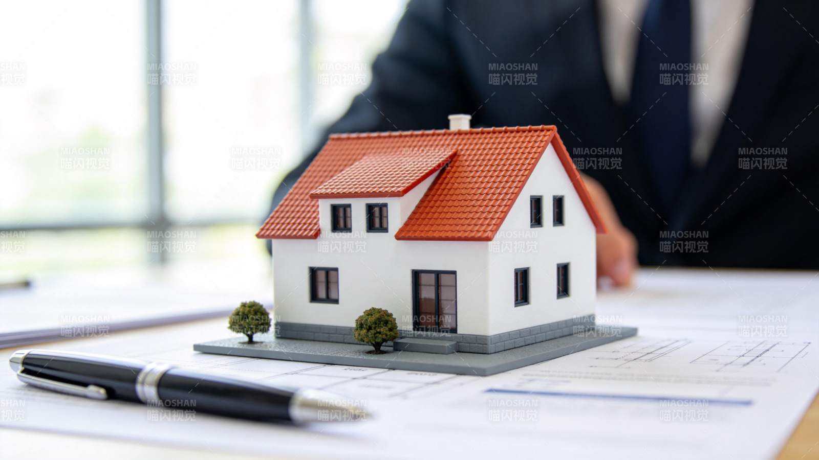 办公桌上房屋模型与图纸文件展示图片