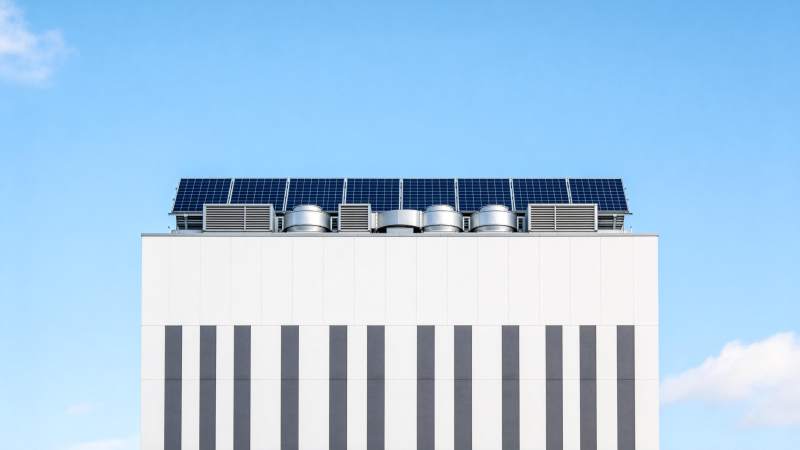 白色建筑屋顶安装太阳能板与通风设备图片