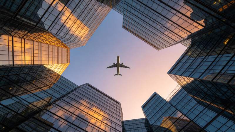 高楼环绕中飞机飞越城市上空图片