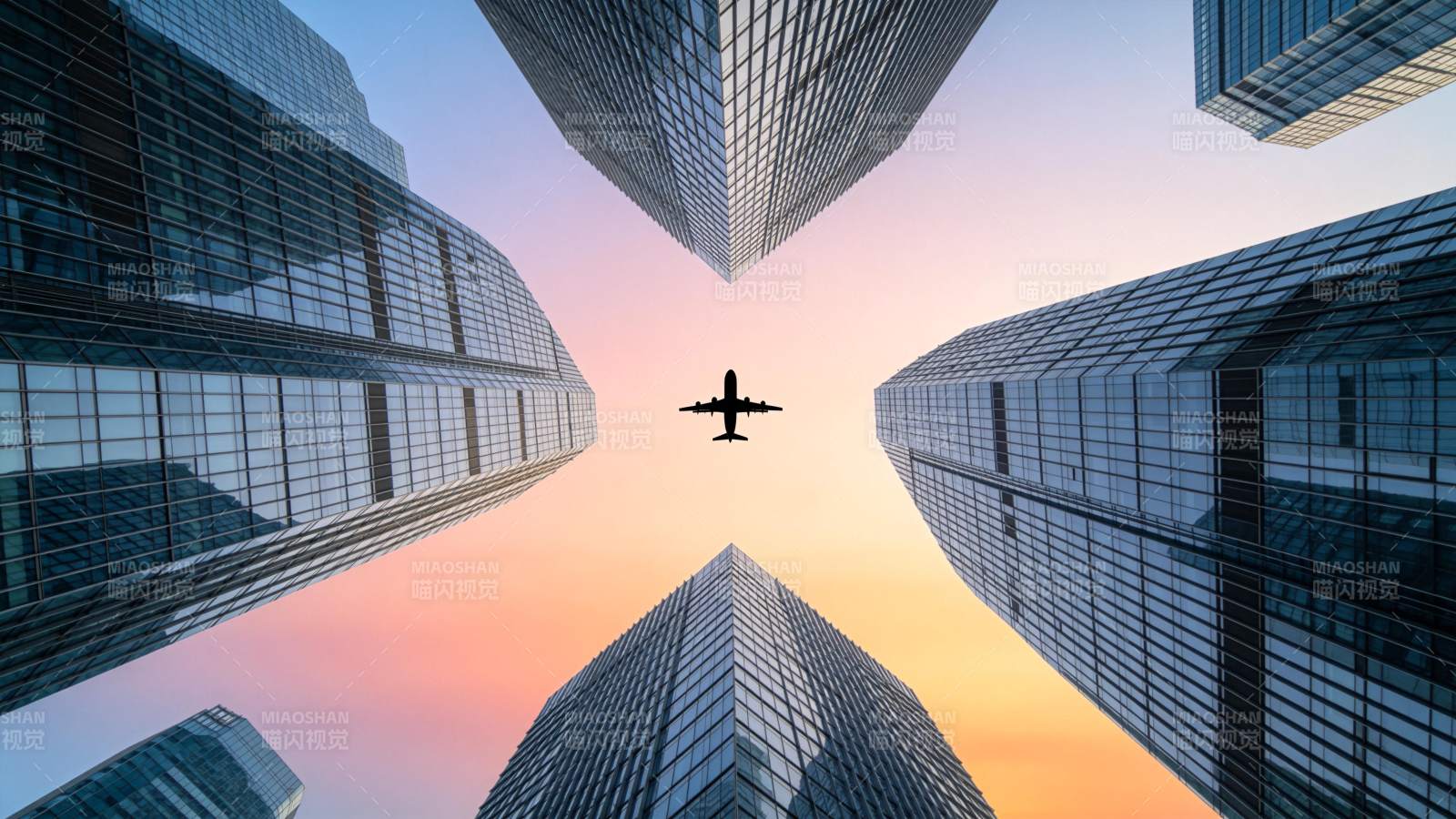 城市高楼间飞行的客机剪影图片