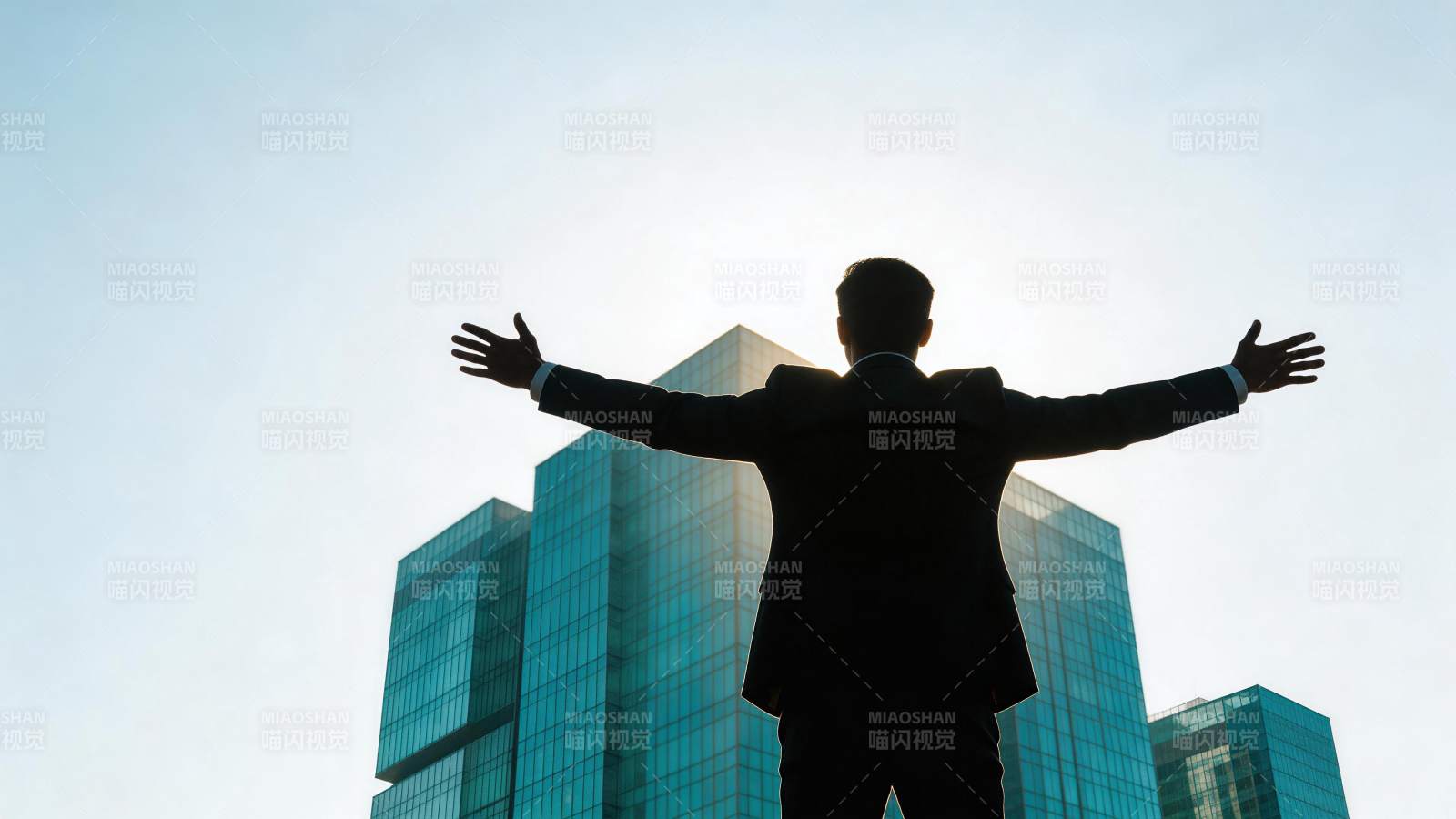 西装男子背对镜头张开双臂面对高楼图片